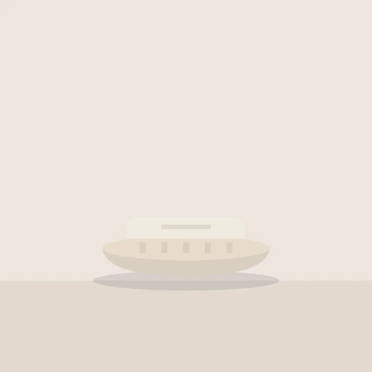 Oval stoneware soap dish holding a pale bar of soap
